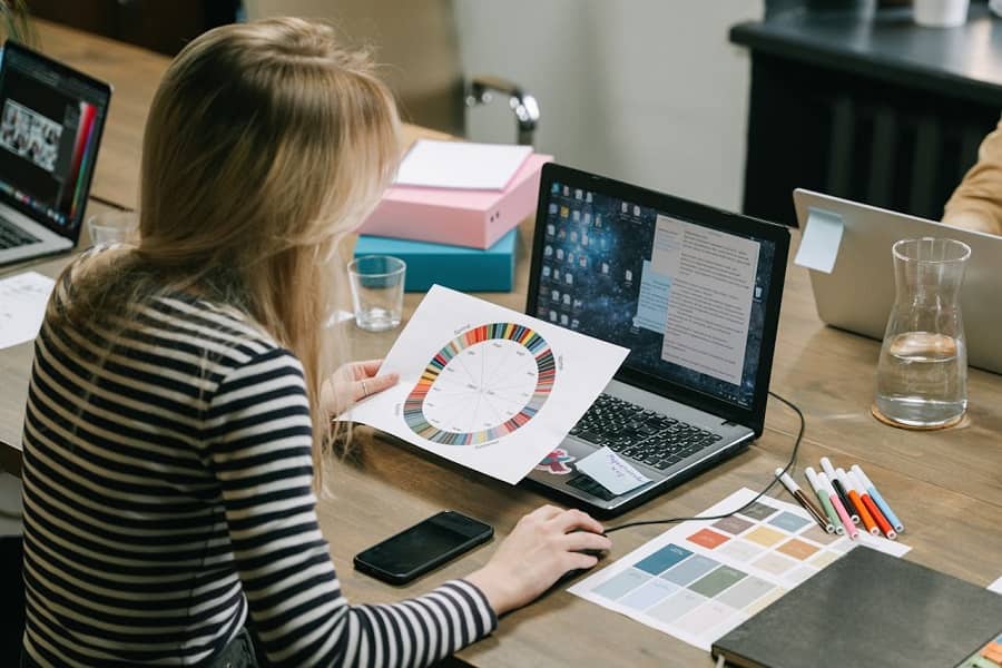 Woman-looking-at-color-wheel-while-using-laptop